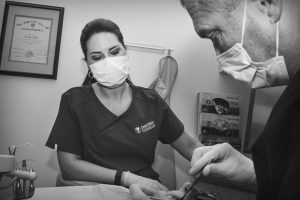 Dr. Canal performing a frenectomy with assistance from dental hygienist